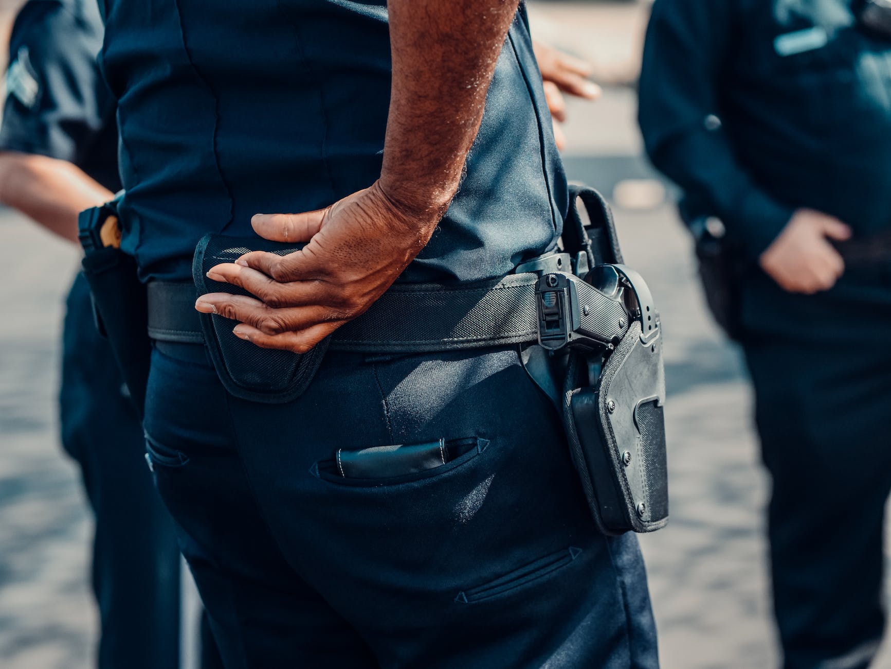 person in blue uniform with a handgun